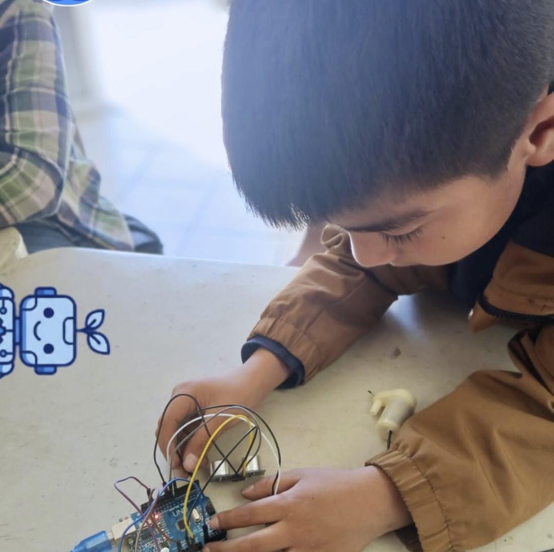 Alumno conectando cables a una placa de desarrollo durante una clase de robótica de CultivaTec