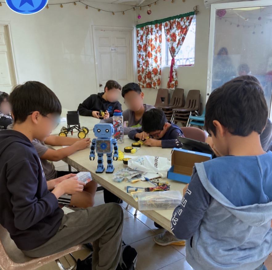 Sesión del club de robótica de CultivaTec en un salón prestado, con un robot armado sobre la mesa
