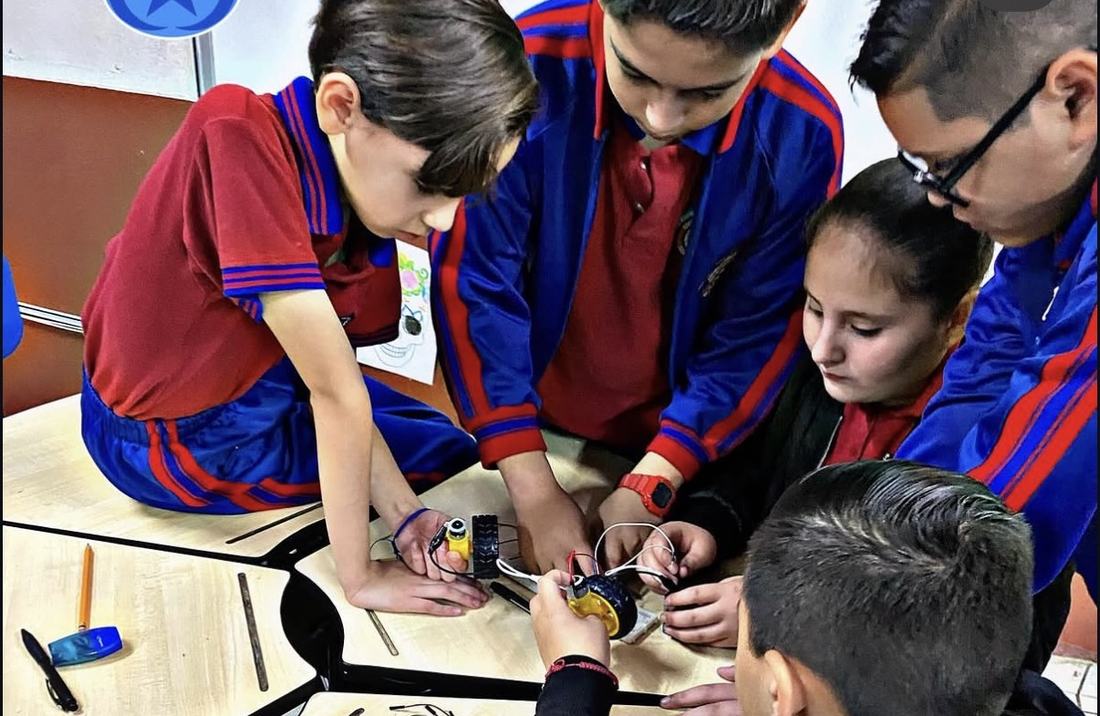 Equipo de alumnos de un colegio armando en conjunto un robot durante el taller de CultivaTec
