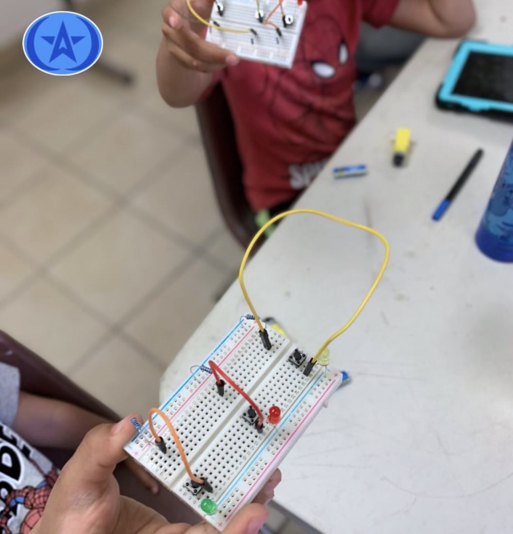 Manos de un alumno sosteniendo una protoboard con un circuito armado en un taller de robótica de CultivaTec